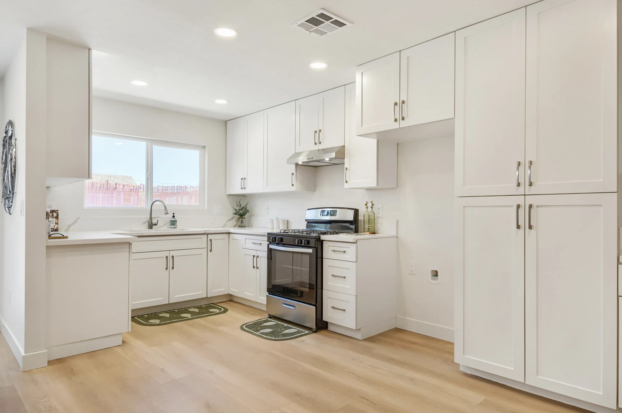 Finished white kitchen cabinetry with stainless steel appliances